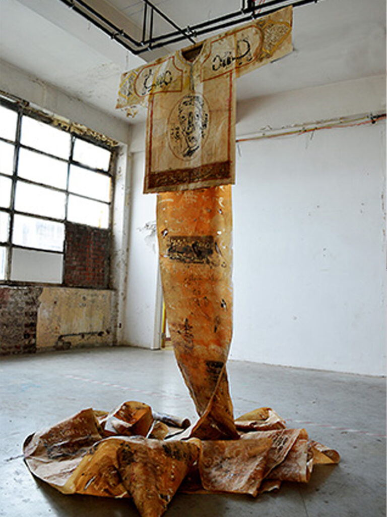 Mixed-media installation

Includes 5 oversized shirts (100 × 200 cm each) and 2 scrolled messages (7 m length each).

Technique: Screen printing, monoprint, and drypoint on coffee-aged Japanese Lokta paper. Features Arabic calligraphy, Islamic ornamentation, geometric Kufic script, and gold leaf detailing.